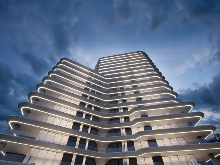 Residential tower at dusk with illuminated balconies
